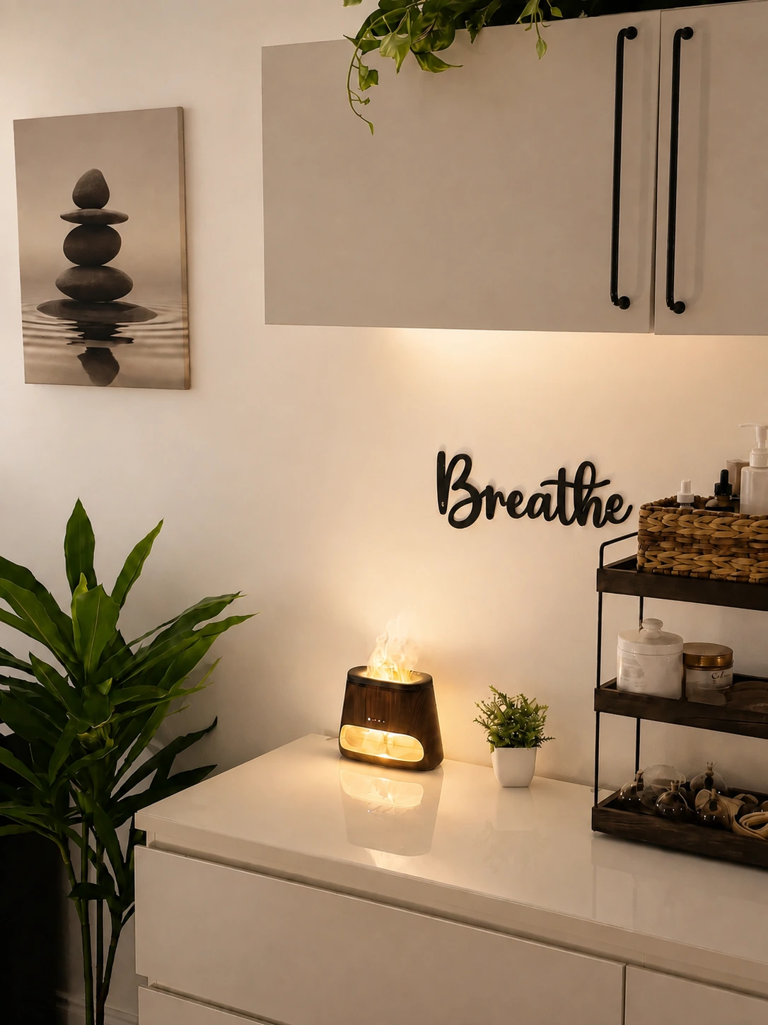A calm corner of the studio with a stone-stack print and diffuser.