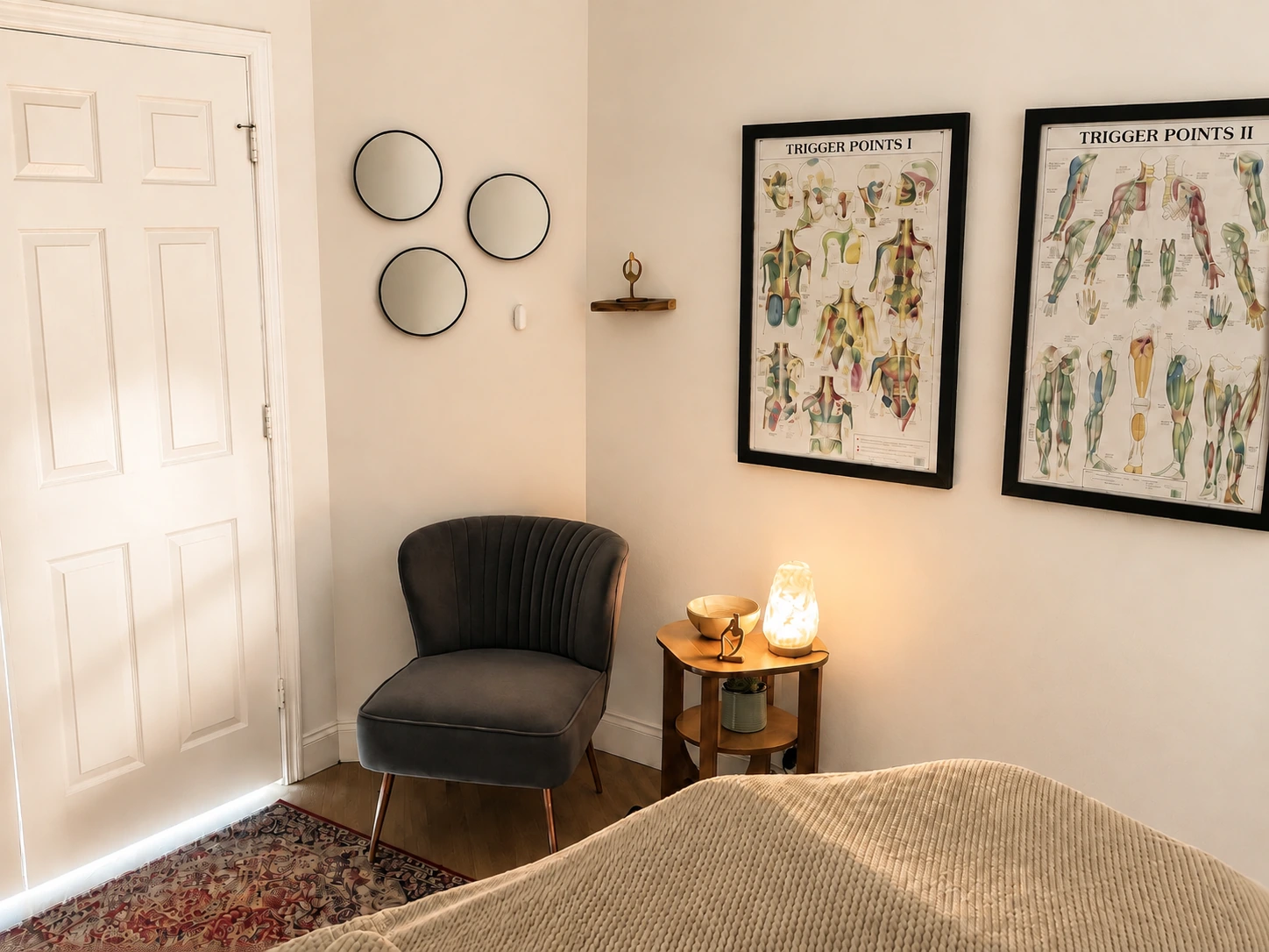 A calm corner of the treatment room with mirrors and framed anatomy charts.